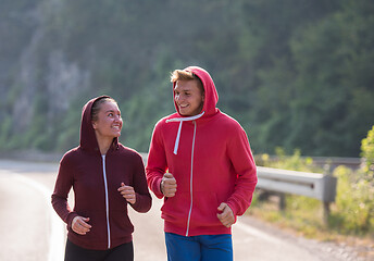 Image showing young couple jogging along a country road