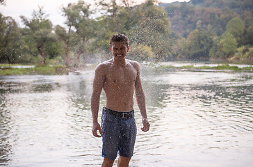 Image showing man with a bare torso splashing water