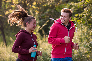 Image showing young couple jogging along a country road