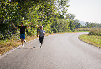 Image showing young couple jogging along a country road