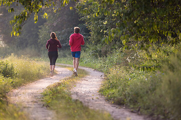 Image showing young couple jogging along a country road