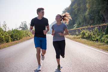 Image showing young couple jogging along a country road