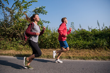 Image showing young couple jogging along a country road