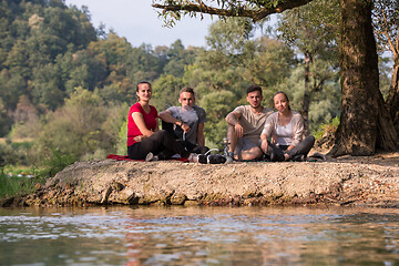 Image showing friends smoking hookah on the river bank