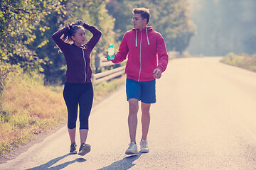 Image showing young couple jogging along a country road