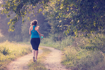 Image showing woman jogging along a country road