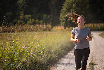 Image showing woman jogging along a country road