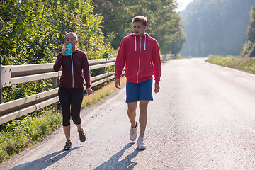 Image showing young couple jogging along a country road