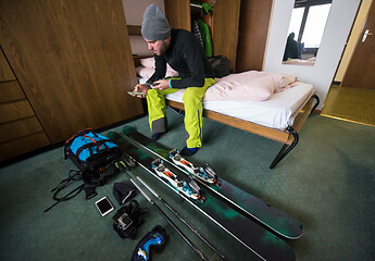 Image showing skier preparing ski accessories