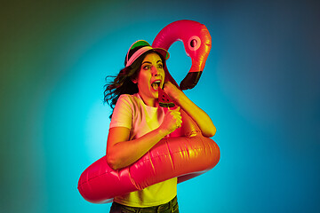 Image showing Happy young woman standing and smiling against blue background