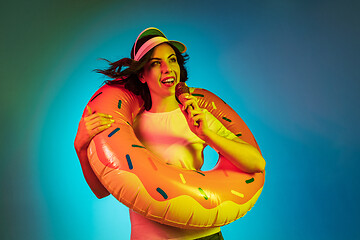 Image showing Happy young woman standing and smiling against blue background