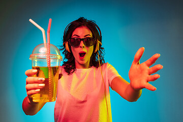 Image showing Happy young woman standing and smiling against blue background