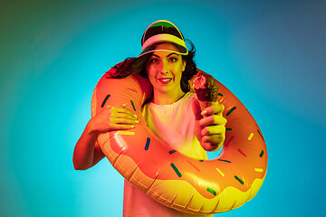 Image showing Happy young woman standing and smiling against blue background