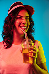 Image showing Happy young woman standing and smiling against blue background