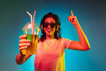 Image showing Happy young woman standing and smiling against blue background