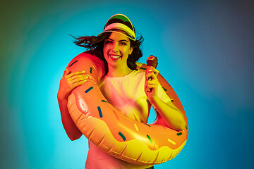 Image showing Happy young woman standing and smiling against blue background