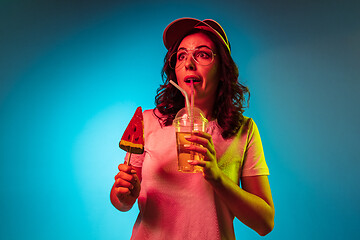 Image showing Happy young woman standing and smiling against blue background