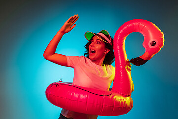 Image showing Happy young woman standing and smiling against blue background