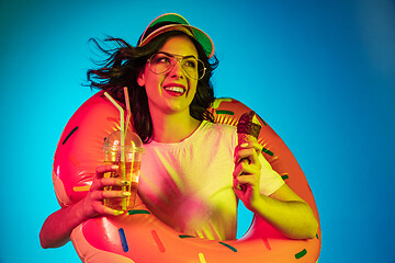 Image showing Happy young woman standing and smiling against blue background