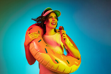 Image showing Happy young woman standing and smiling against blue background