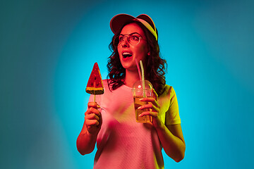 Image showing Happy young woman standing and smiling against blue background