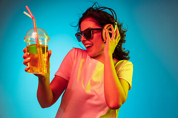 Image showing Happy young woman standing and smiling against blue background