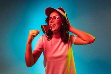 Image showing Happy young woman standing and smiling against blue background