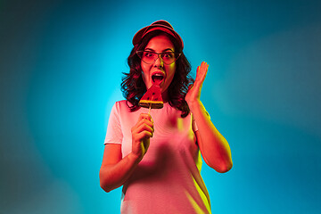 Image showing Happy young woman standing and smiling against blue background