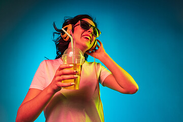 Image showing Happy young woman standing and smiling against blue background