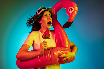 Image showing Happy young woman standing and smiling against blue background