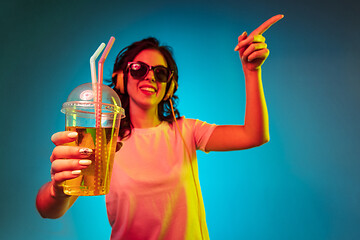 Image showing Happy young woman standing and smiling against blue background