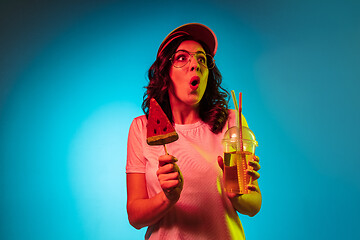 Image showing Happy young woman standing and smiling against blue background