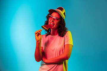 Image showing Happy young woman standing and smiling against blue background