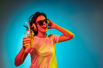 Image showing Happy young woman standing and smiling against blue background