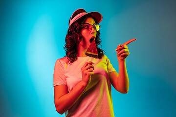 Image showing Happy young woman standing and smiling against blue background