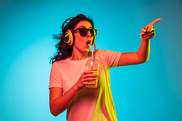 Image showing Happy young woman standing and smiling against blue background