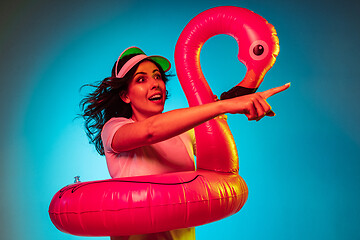 Image showing Happy young woman standing and smiling against blue background