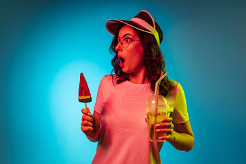 Image showing Happy young woman standing and smiling against blue background