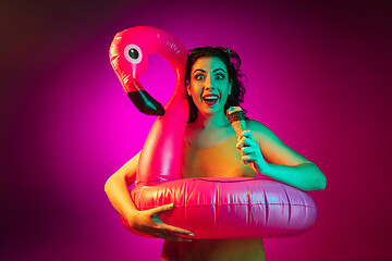 Image showing Happy young woman standing and smiling against pink background
