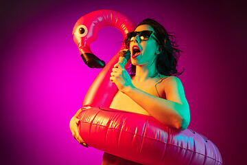 Image showing Happy young woman standing and smiling against pink background