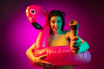 Image showing Happy young woman standing and smiling against pink background