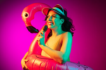 Image showing Happy young woman standing and smiling against pink background