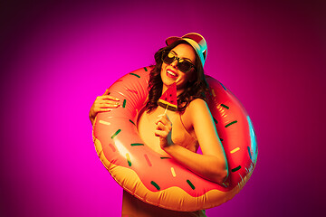 Image showing Happy young woman standing and smiling against pink background