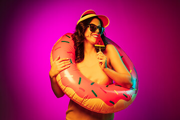 Image showing Happy young woman standing and smiling against pink background