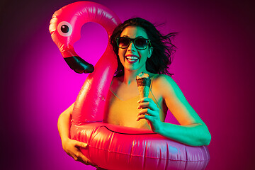 Image showing Happy young woman standing and smiling against pink background