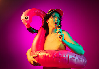 Image showing Happy young woman standing and smiling against pink background