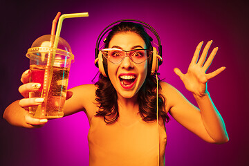 Image showing Happy young woman standing and smiling against pink background