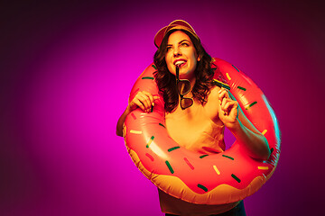 Image showing Happy young woman standing and smiling against pink background