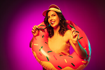 Image showing Happy young woman standing and smiling against pink background