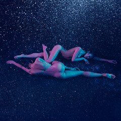 Image showing Two young female ballet dancers under water drops